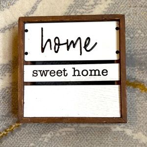 Wooden “Home sweet home” sign with white metal planks.
